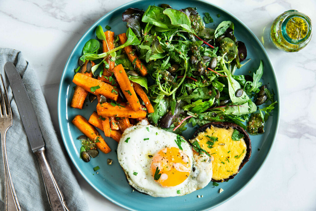 Portobello-Pilze mit Käse und Spiegelei an Salat mit Schnittlauch und Kürbiskernen