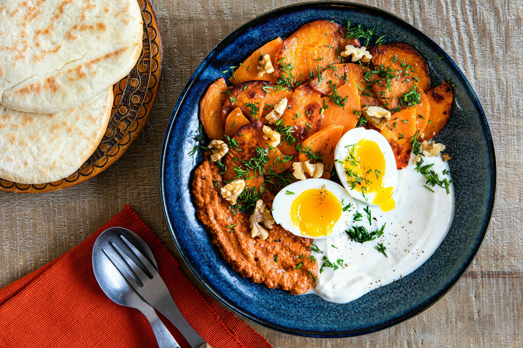 Ei an pikanter Paprika-Walnuss-Sauce mit Süßkartoffel, Joghurt und Pita