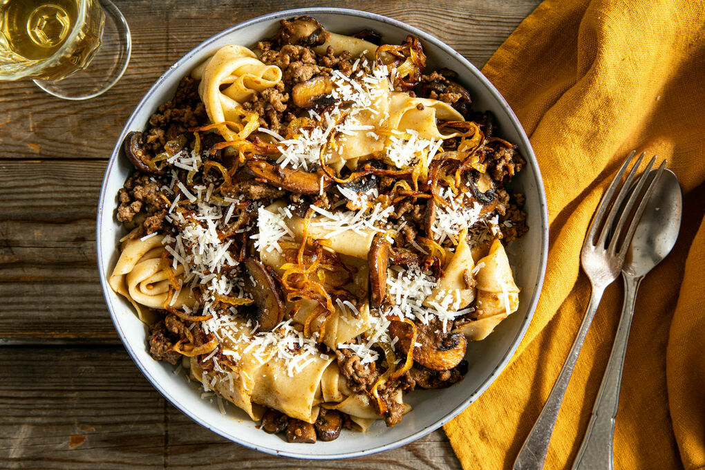 Pappardelle mit Champignon-Bolognese garniert mit gerösteten Zwiebeln und Käse