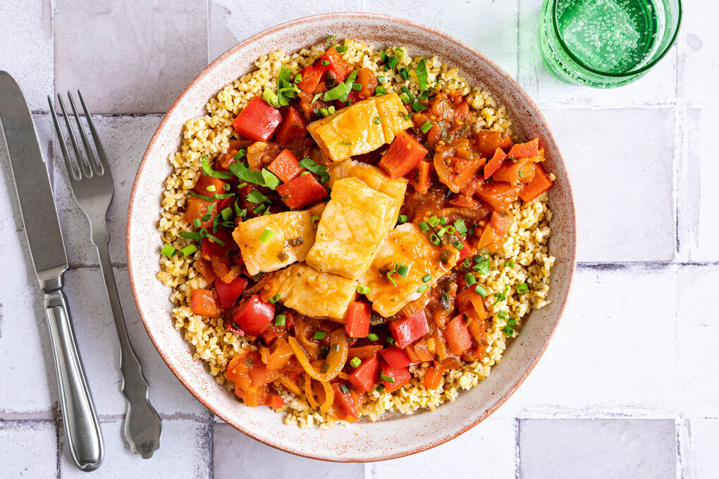 Kabeljau in Paprika-Tomatensauce mit Schnittknoblauch auf Bulgur