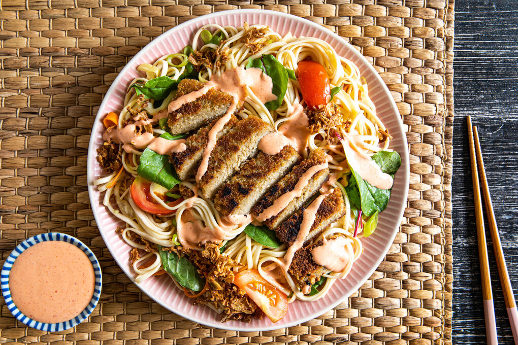 Bohnenschnitzel auf Udon-Nudeln mit Weißkohl, Babymangold und Sesamdressing