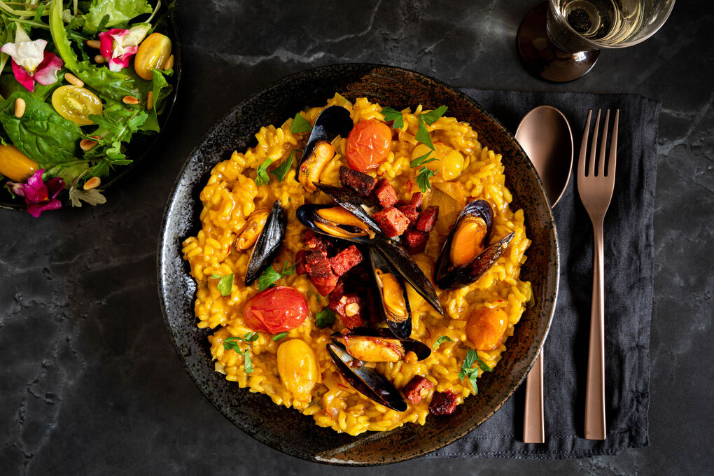 Miesmuscheln auf Safran-Chorizo-Risotto dazu bunter Salat mit Blüten
