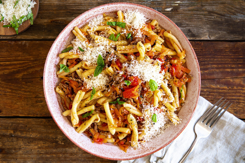 Penne mit Sauce bolognese mit Karotten und frischem Basilikum