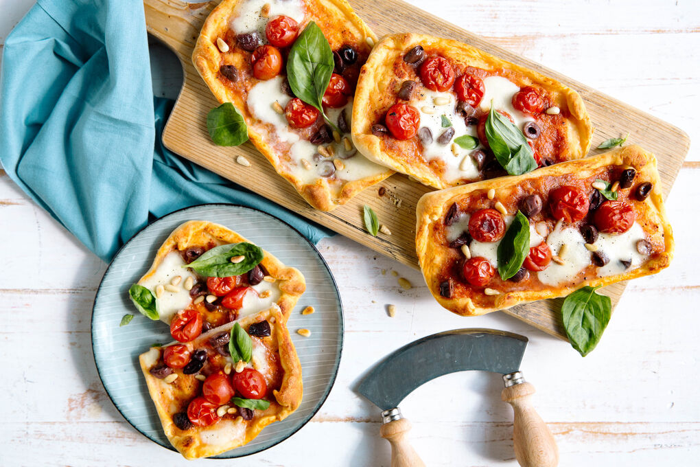 Kirschtomaten-Oliven-Pizzen mit Mozzarella und Pinienkernen