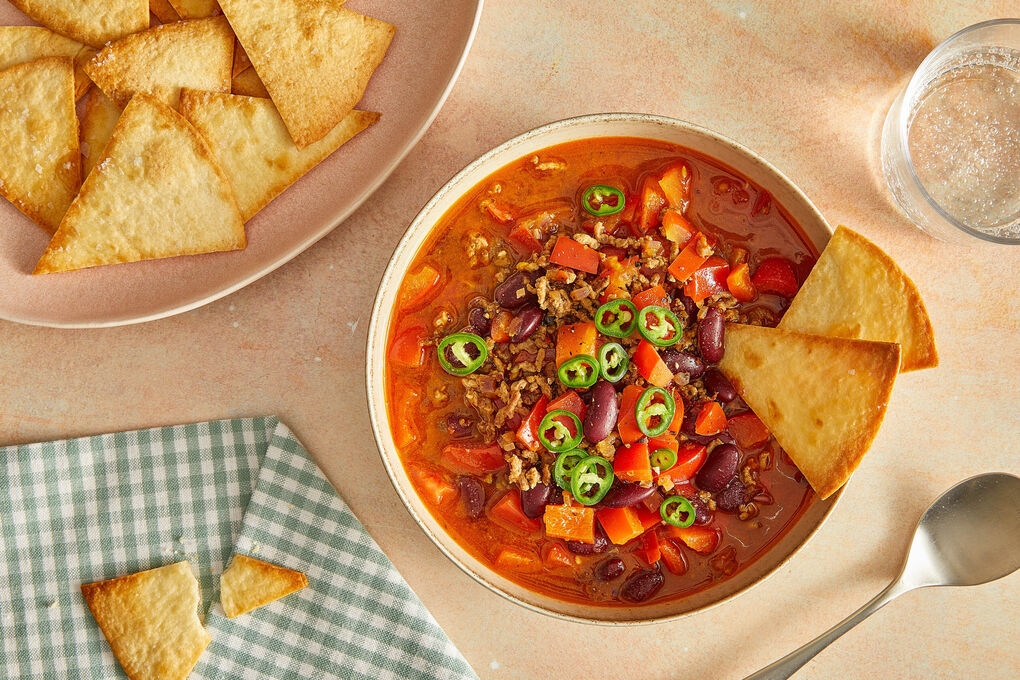 V2: Chili con Carne mit Bio-Rinderhack serviert mit Jalapeño-Topping & Tortillachips