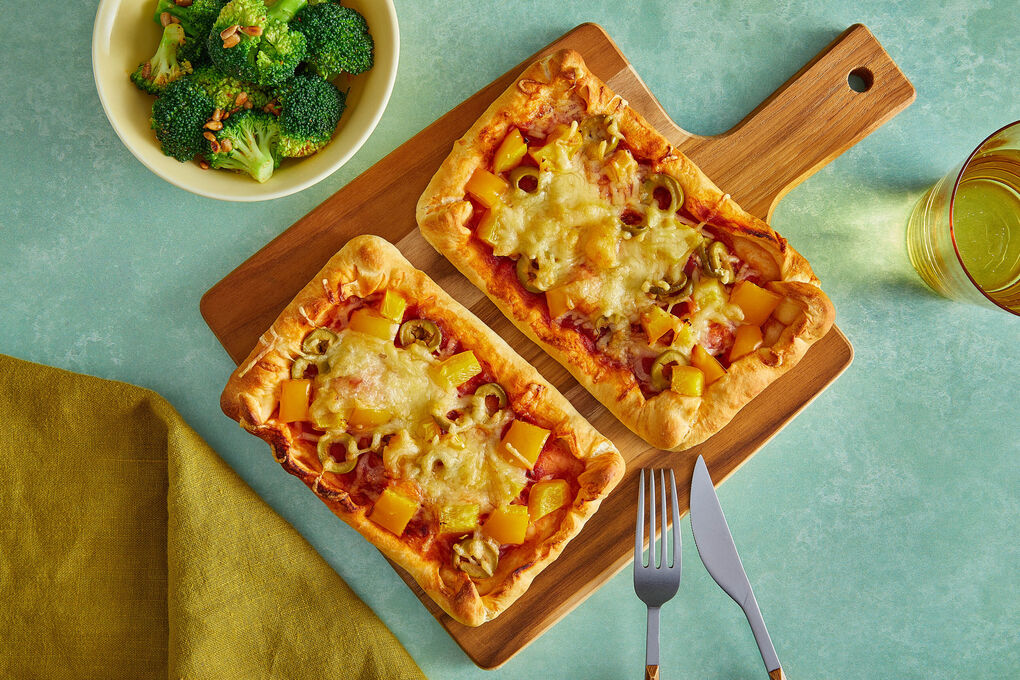 Minipizzen mit Paprika und Oliven an Cajun-Brokkoli mit Sonnenblumenkernen