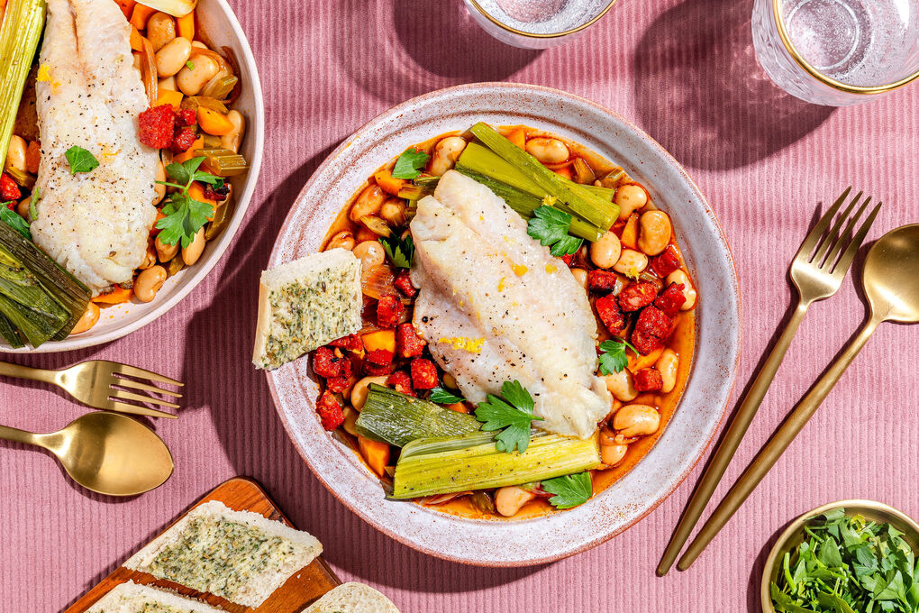 Zartes Seebarschfilet auf Bohneneintopf mit gebackenem Lauch und Chorizo-Croûtons