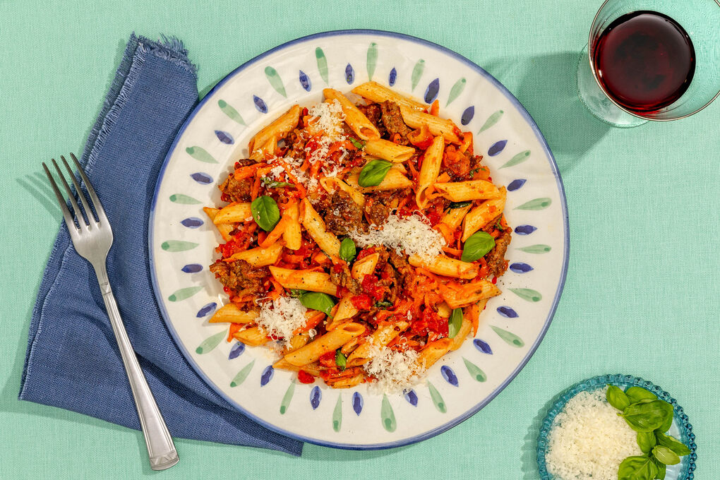 Penne mit Sauce bolognese mit Karotten und frischem Basilikum