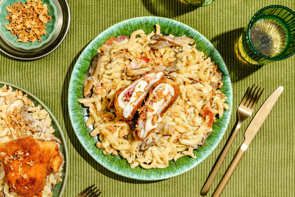 Hähnchenschnitzel à la Cordon Bleu auf Spätzle in cremiger Pilzsauce mit Speck