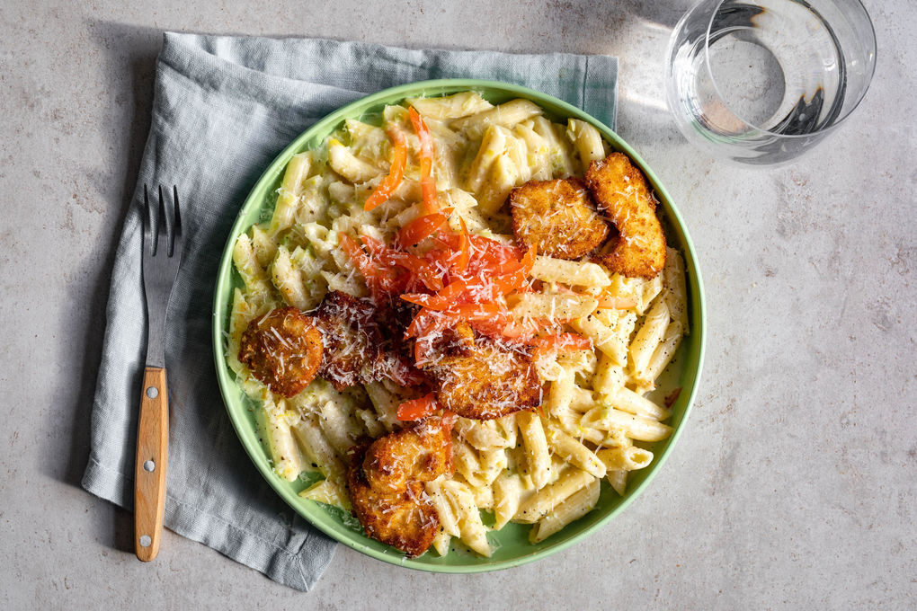 Knusprige Hähnchennuggets auf cremiger Lauch-Pasta mit Käse