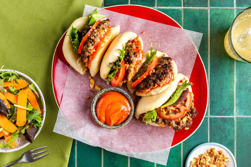 Smashed-Burger-Baos mit Käse und Tomaten dazu Karottensalat und Sriracha-Dip