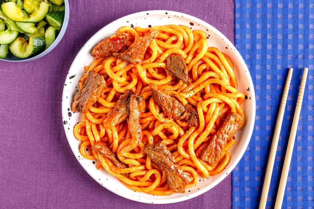 Scharfe Rindfleisch-Nudelpfanne mit Austernpilzen und Gurkensalat