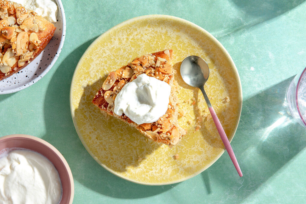 Saftiger Tahinikuchen mit Mandel-Sesam-Topping und Schlagsahne