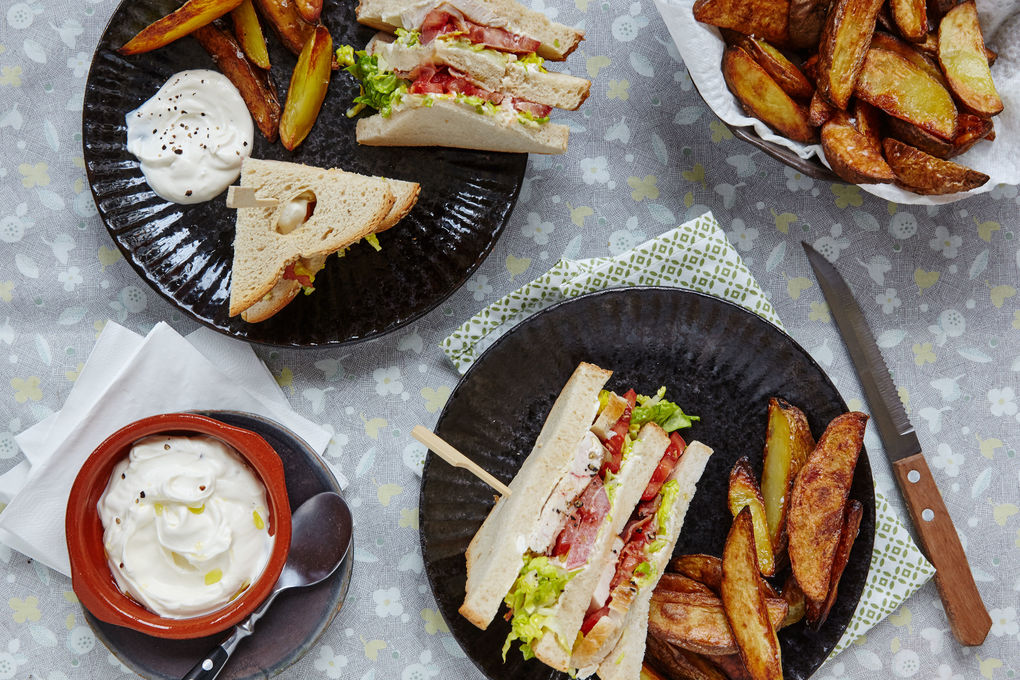 Saftiges Clubsandwich mit Wedges und Schmanddip