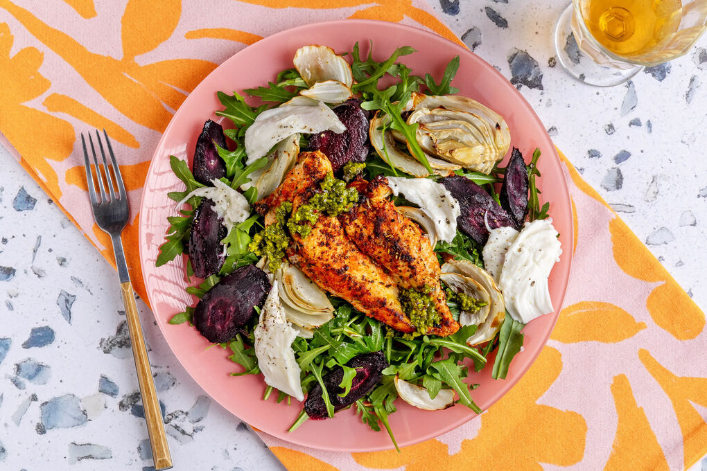 Saftiges Bio-Hähnchen und Ofengemüse auf Rucola mit Mozzarella und Pistazienpesto