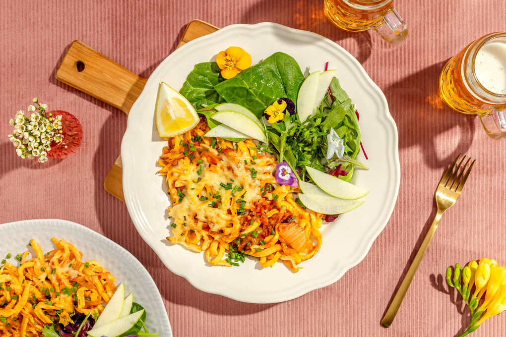 Scharfe Käsespätzle mit Kimchi und Lauch an feinem Salat mit Apfel und Blüten