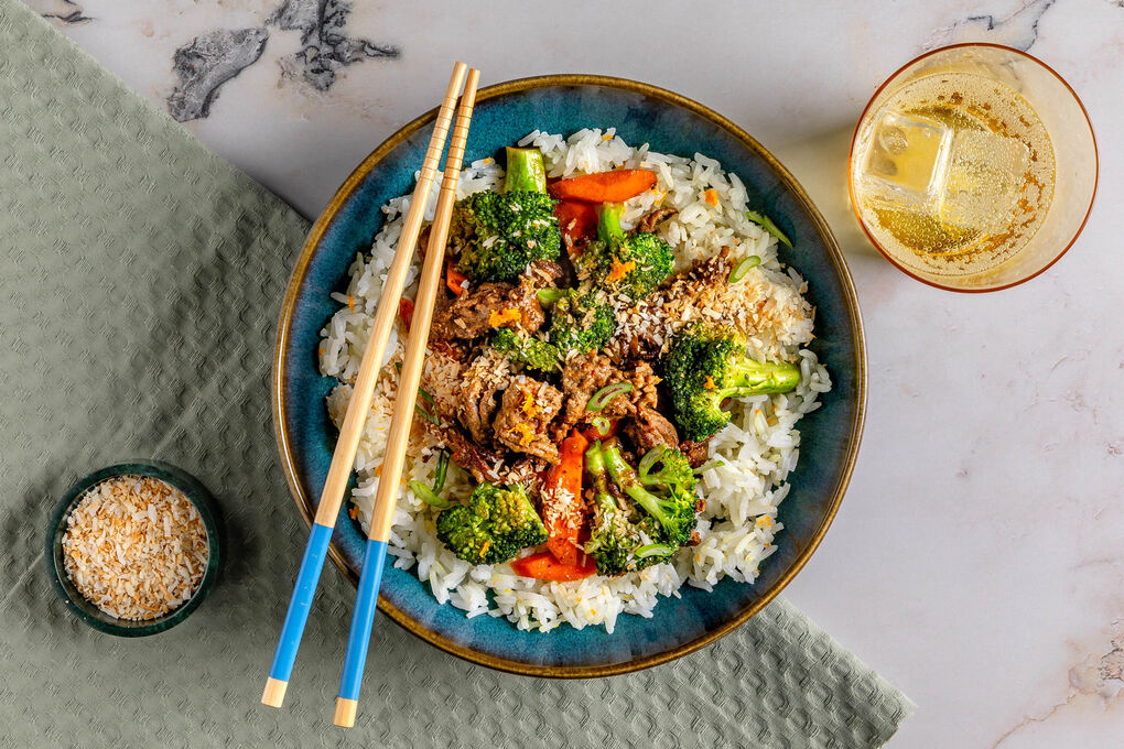 Brokkoli-Hackfleisch-Pfanne mit Orange garniert mit Kokosraspel, dazu Reis
