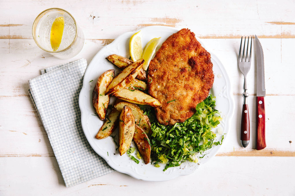 Paniertes Schweineschnitzel mit Backkartoffeln und Salat
