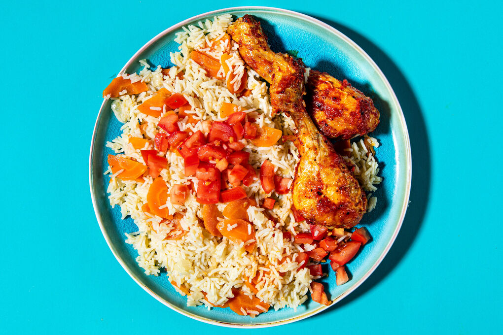 Feuriges Harissa-Hähnchen aus dem Ofen auf Gemüsereis mit frischen Tomaten