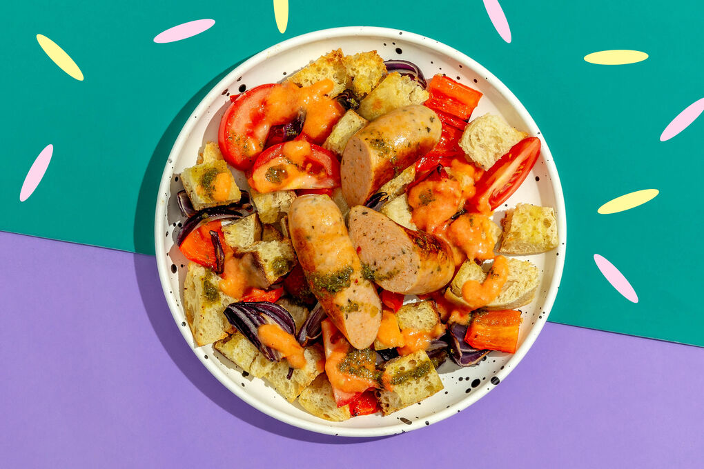 Geflügelwurst auf buntem Brotsalat mit Röstgemüse und Basilikumcreme