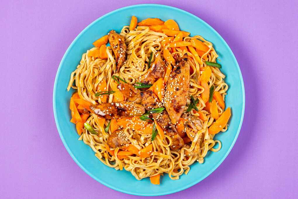Asia-Schweinegeschnetzeltes mit Mie-Nudeln mit Karotten und weißem Sesam