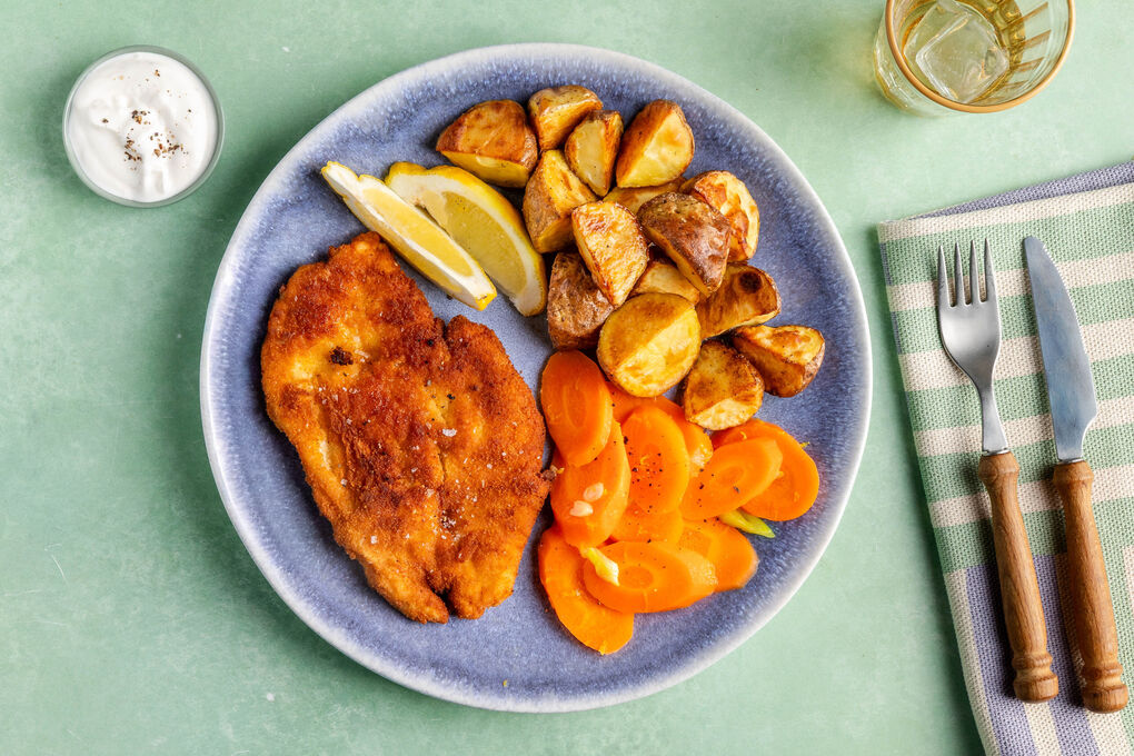 Hähnchenschnitzel mit Röstkartoffeln dazu Karotten, Zitrone und Saure-Sahne-Dip