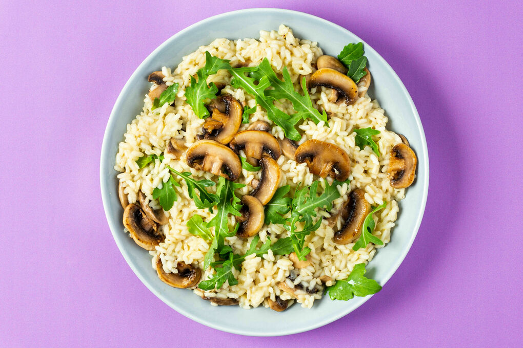 Veganes Pilzrisotto mit Hefeflocken verfeinert mit pfeffrigem Rucola