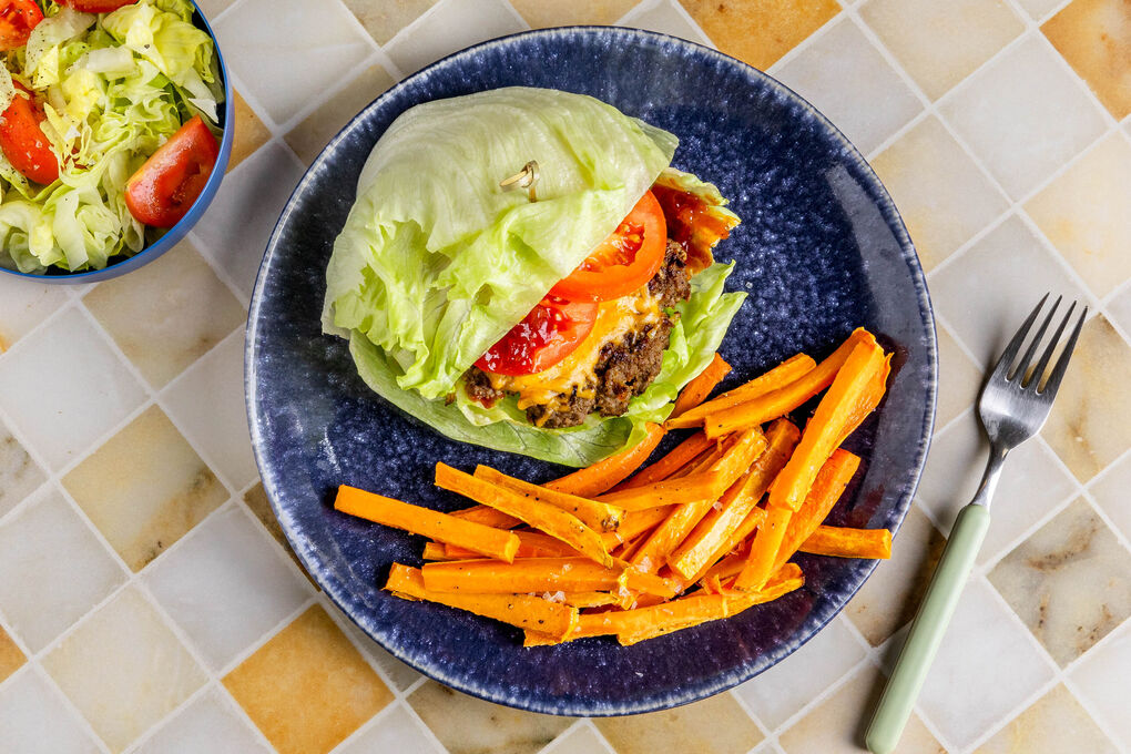 BBQ-Cheeseburger in Salatwraps mit Tomaten und Gemüsepommes
