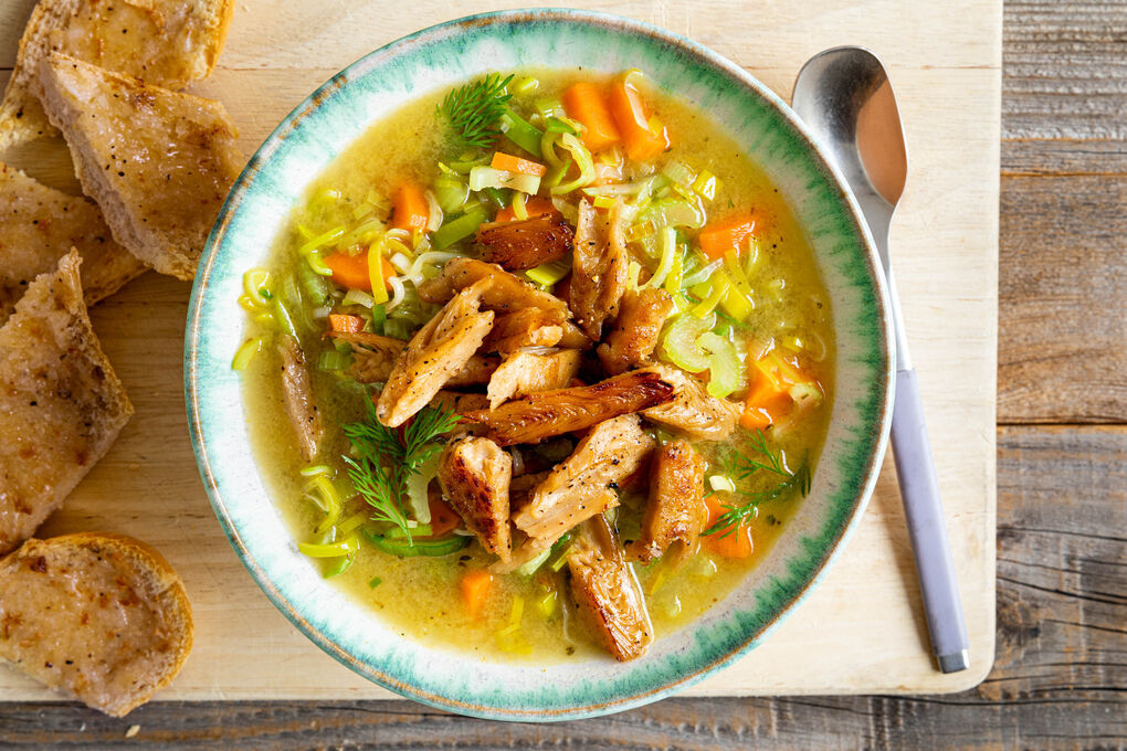 Gemüsesuppe mit veganem „Hähnchen“ dazu knofeliges Vollkornbaguette