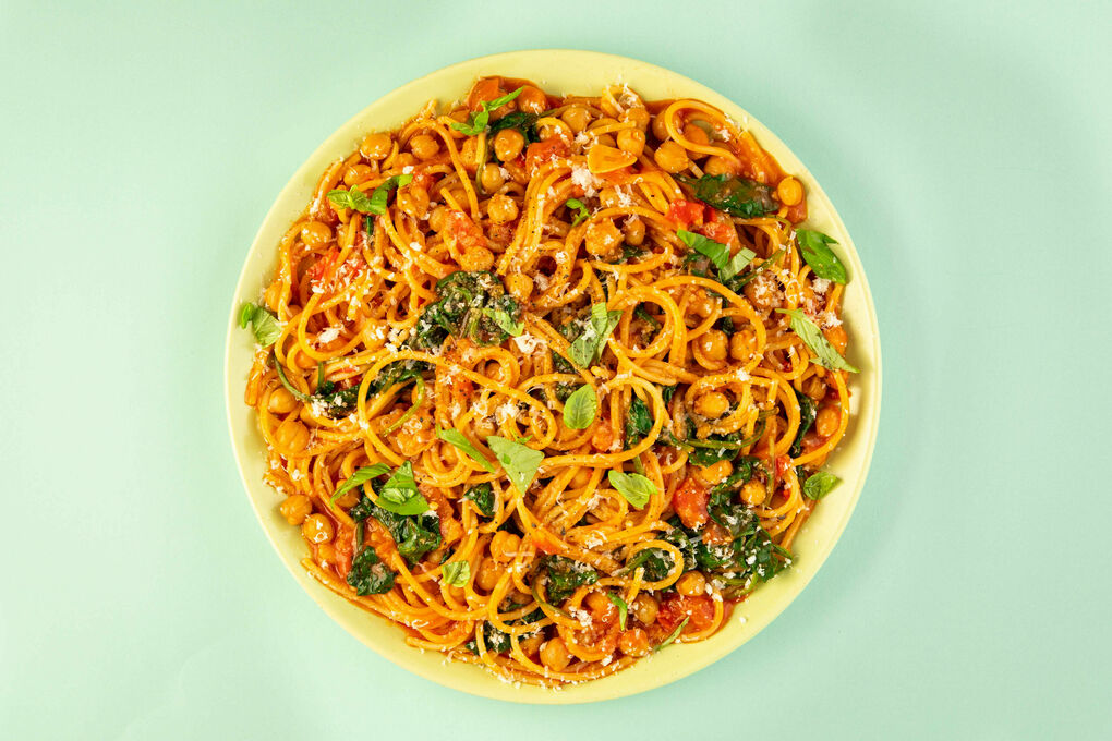 Spaghetti mit Spinat und Kichererbsen mit frischem Basilikum und geriebenem Käse