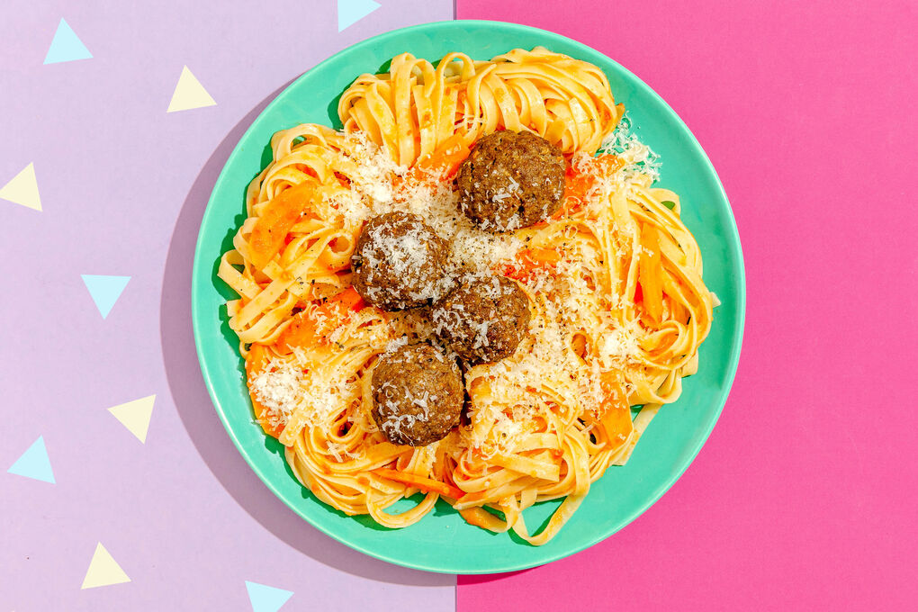Pasta mit würzigen Hackbällchen serviert auf frischer Tomatensauce