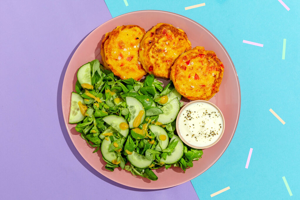 Kichererbsenpuffer mit Sour-Cream-Dip an Feldsalat mit knackiger Gurke