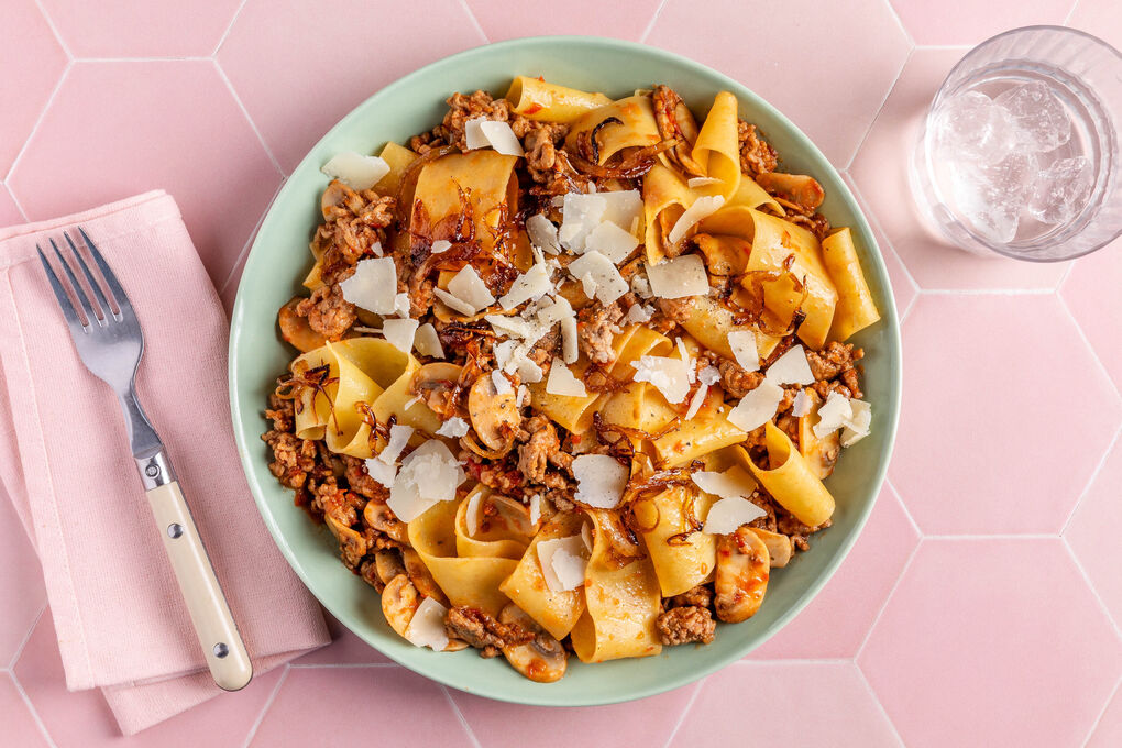 Champignon-Hack-Bolognese mit Pappardelle garniert mit gerösteten Zwiebeln und Käse