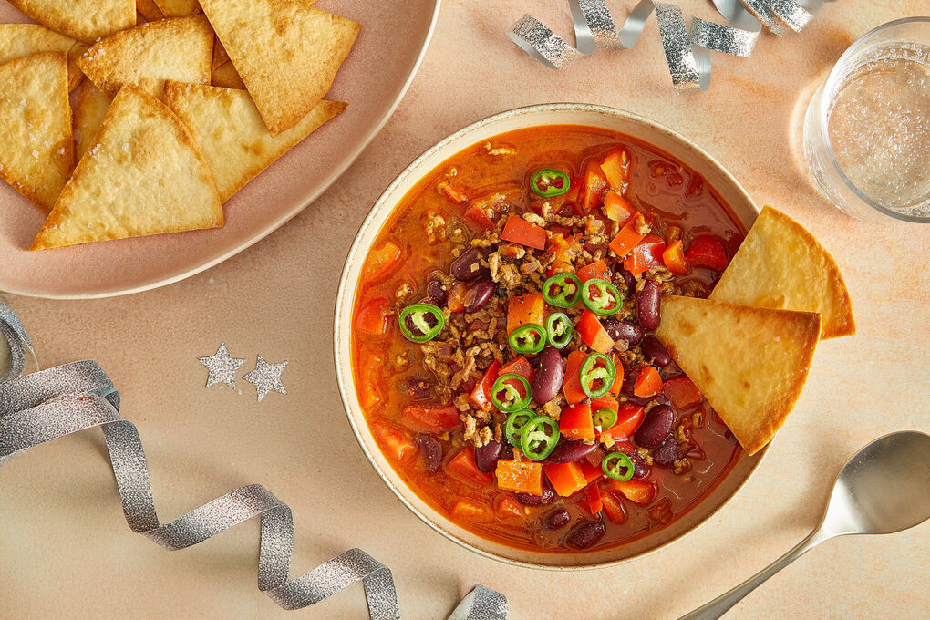 Chili con Carne mit Rinderhack serviert mit Jalapeño-Topping & Tortillachips