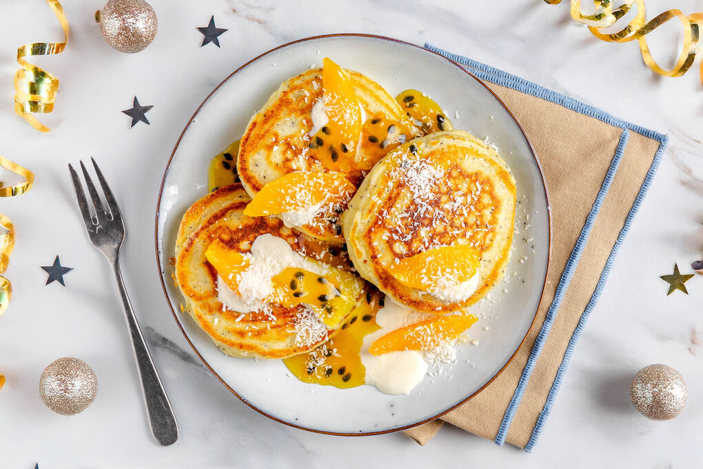 Passionsfrucht-Pancakes serviert mit Joghurt und Kokosraspeln
