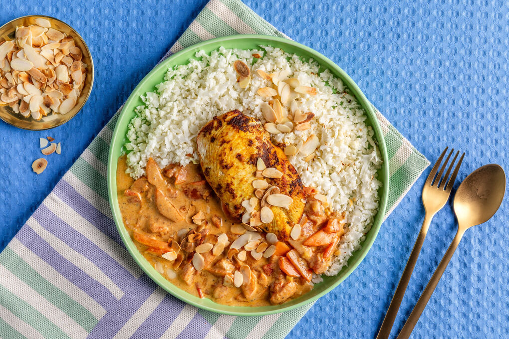 Hähnchen in indischer Curry-Joghurt-Sauce mit Gemüse und Mandeln, dazu Blumenkohlreis