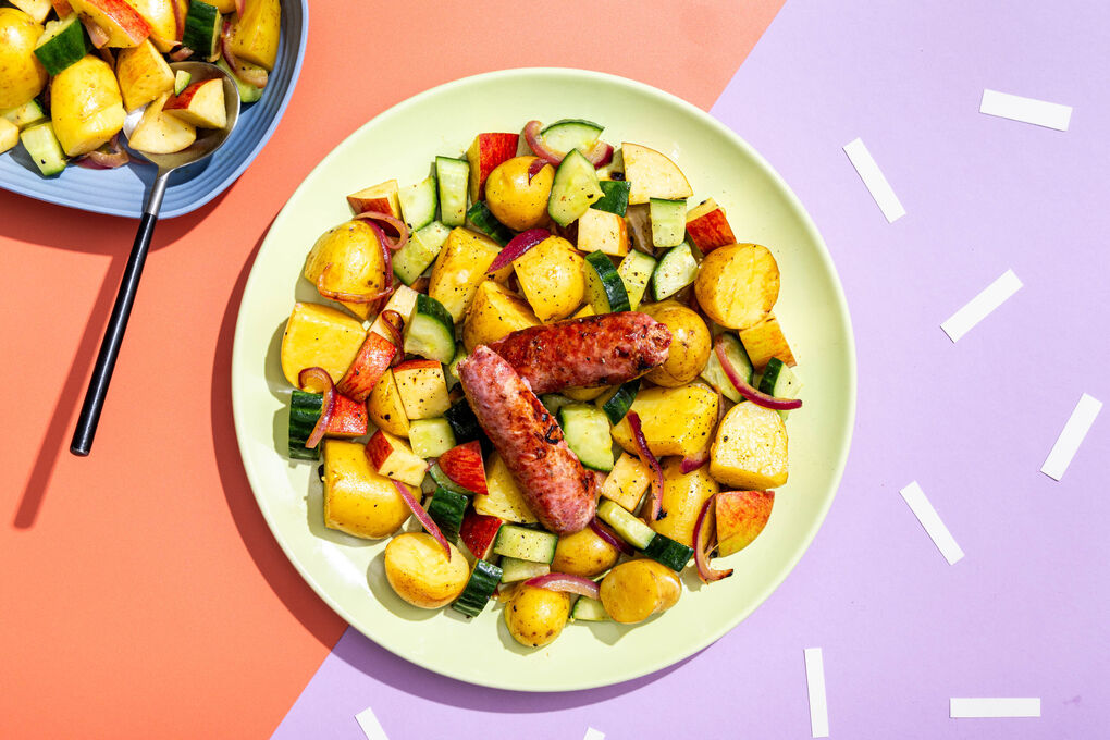 Schweinswurst auf Kartoffel-Gurken-Salat mit Zwiebeln und frischem Apfel