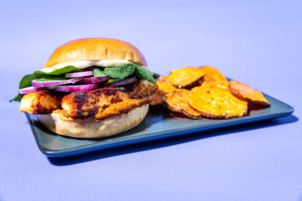 Paneer-Burger mit Currydip an Spinatsalat und Süßkartoffelscheiben