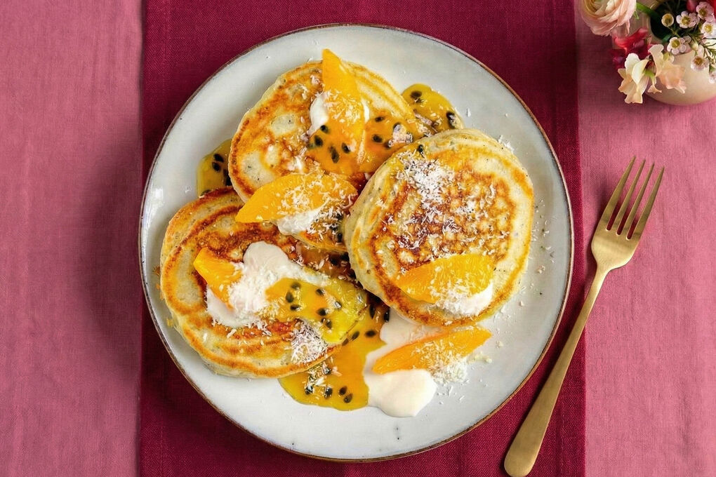 Passionsfrucht-Pancakes serviert mit Joghurt und Kokosraspeln