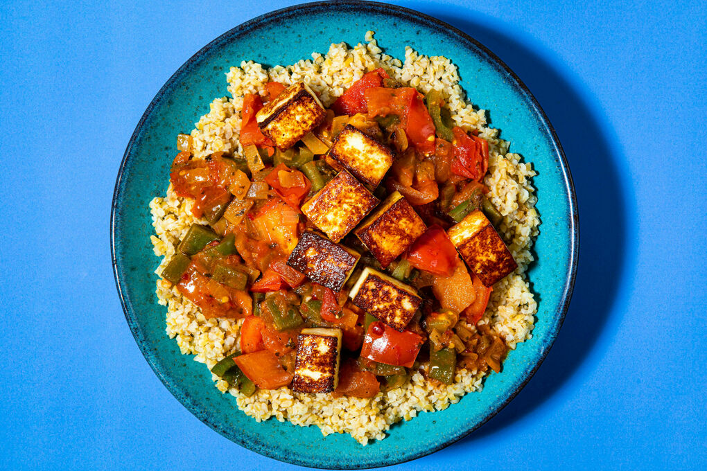 Gebratener Paneer auf Gemüseeintopf dazu fluffiger Bulgur