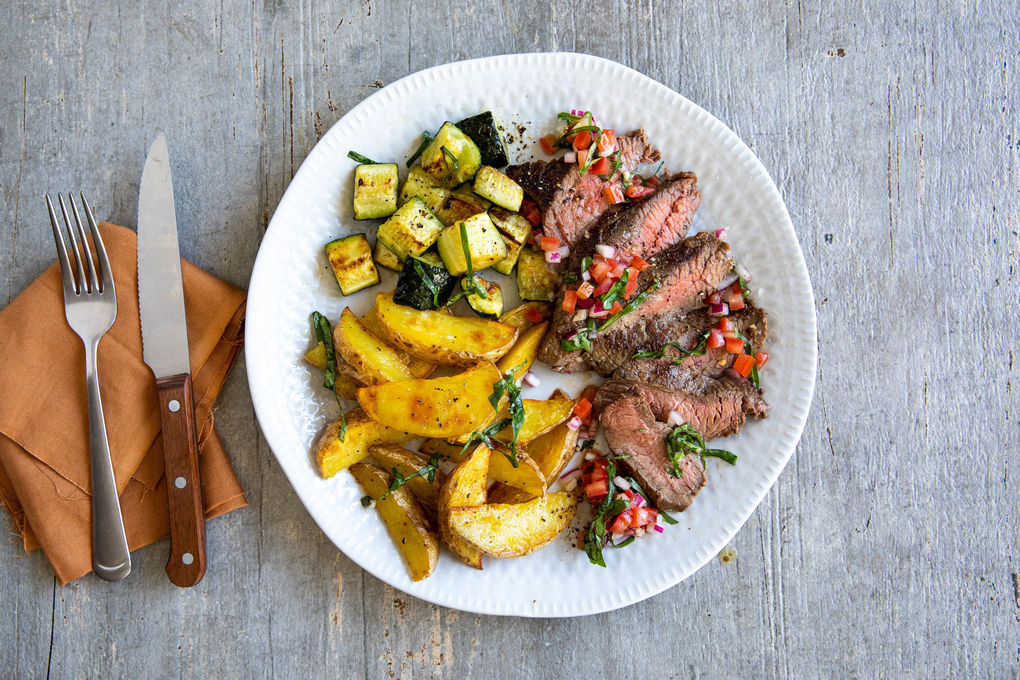 Bio-Rindersteak mit Bruschetta-Salsa dazu gebackene Kartoffeln und Zucchini