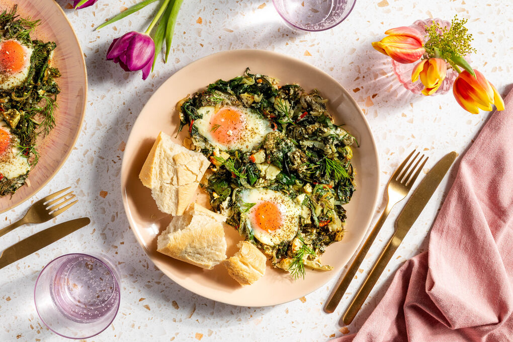 Grüne Feta-Spinat-Shakshuka serviert mit knusprigem Baguette