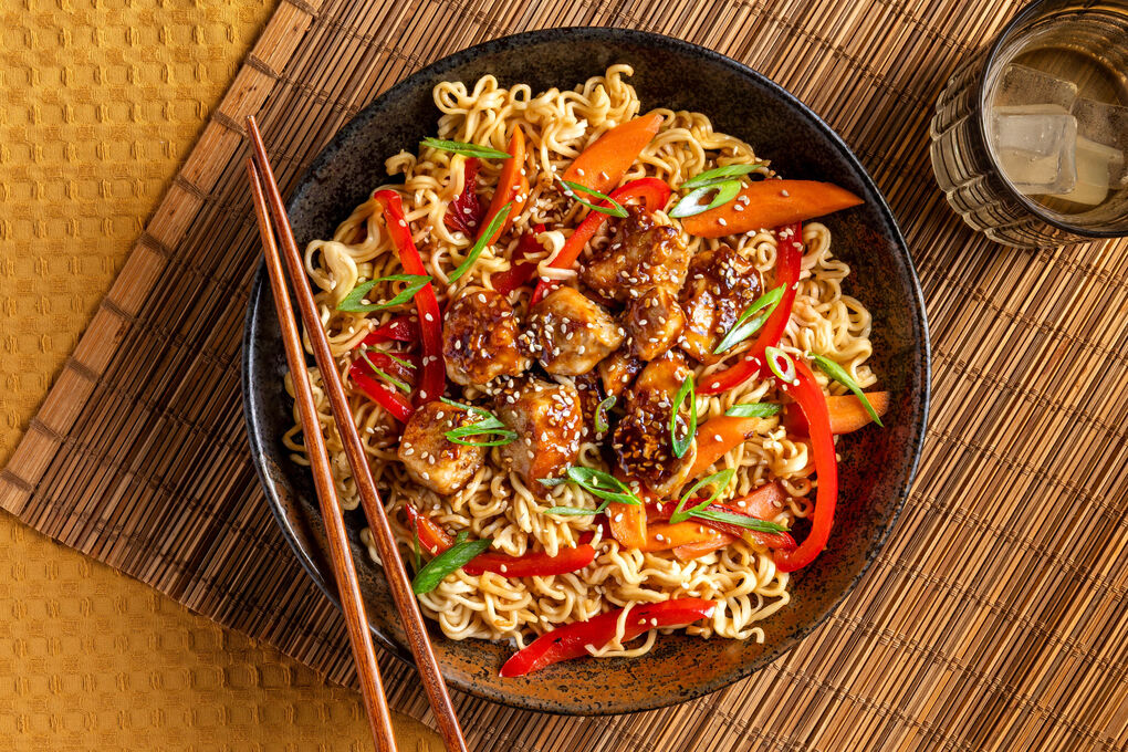 Asia-Nudelpfanne mit Sesam-Hähnchen mit Karotten, Paprika und Lauchzwiebeln