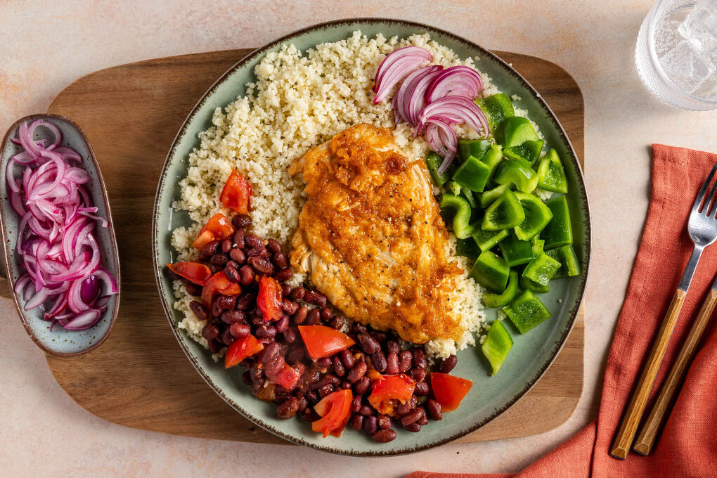 Knuspriges Hähnchen mit schwarzen Bohnen dazu Couscous und grüne Paprika