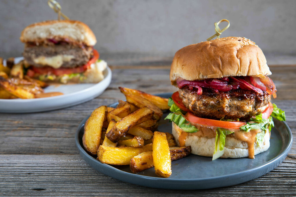 Cheeseburger mit Schweinehack und karamellisierten Zwiebeln, dazu Pommes