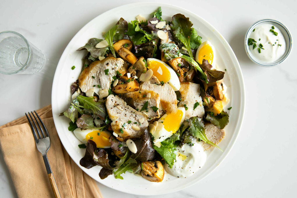 Hähnchensalat mit hartgekochtem Ei mit gebratenen Pilzen und rotem Blattsenf