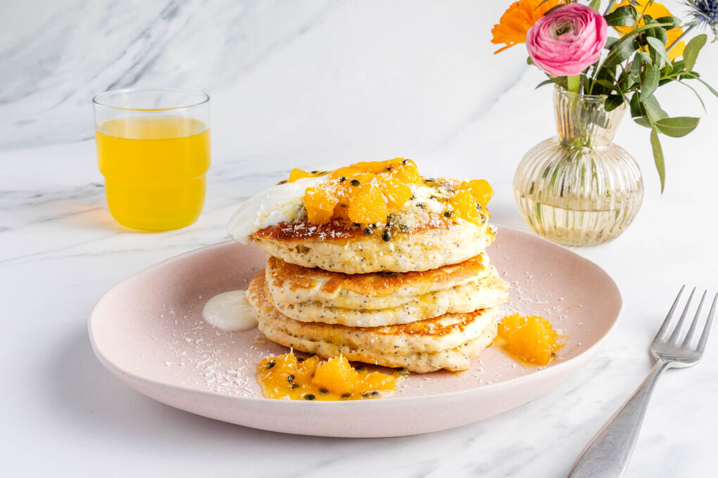 Passionsfrucht-Pancakes serviert mit Joghurt und Kokosraspeln