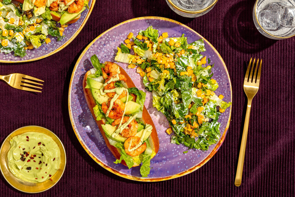 Garnelen-Hotdog Cajun-Style mit Avocadocreme und geröstetem Maissalat