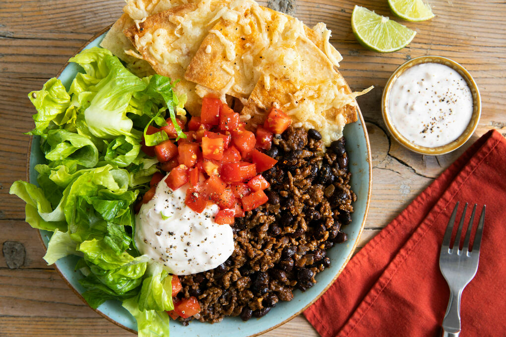 Burrito Bowl mit Rinderhack und Bohnen mit Salsa und Tortillachips mit Käse