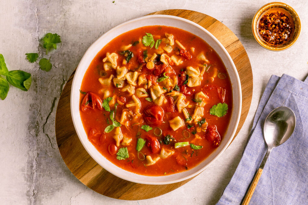 Würzig-scharfe Manti-Suppe mit Chiliöl mit Kirschtomaten und Lauchzwiebeln